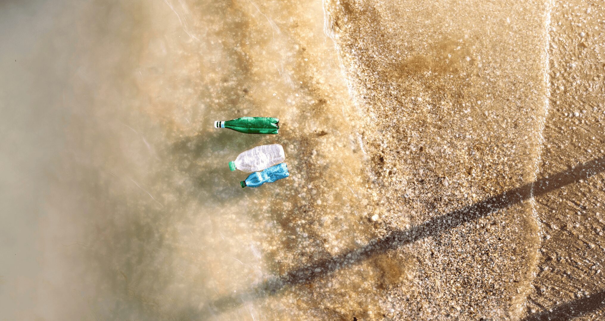 aerial view of plastic bottles floating on the beach