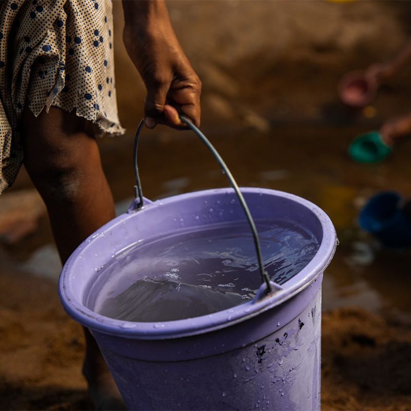 woman carrying bucket of water