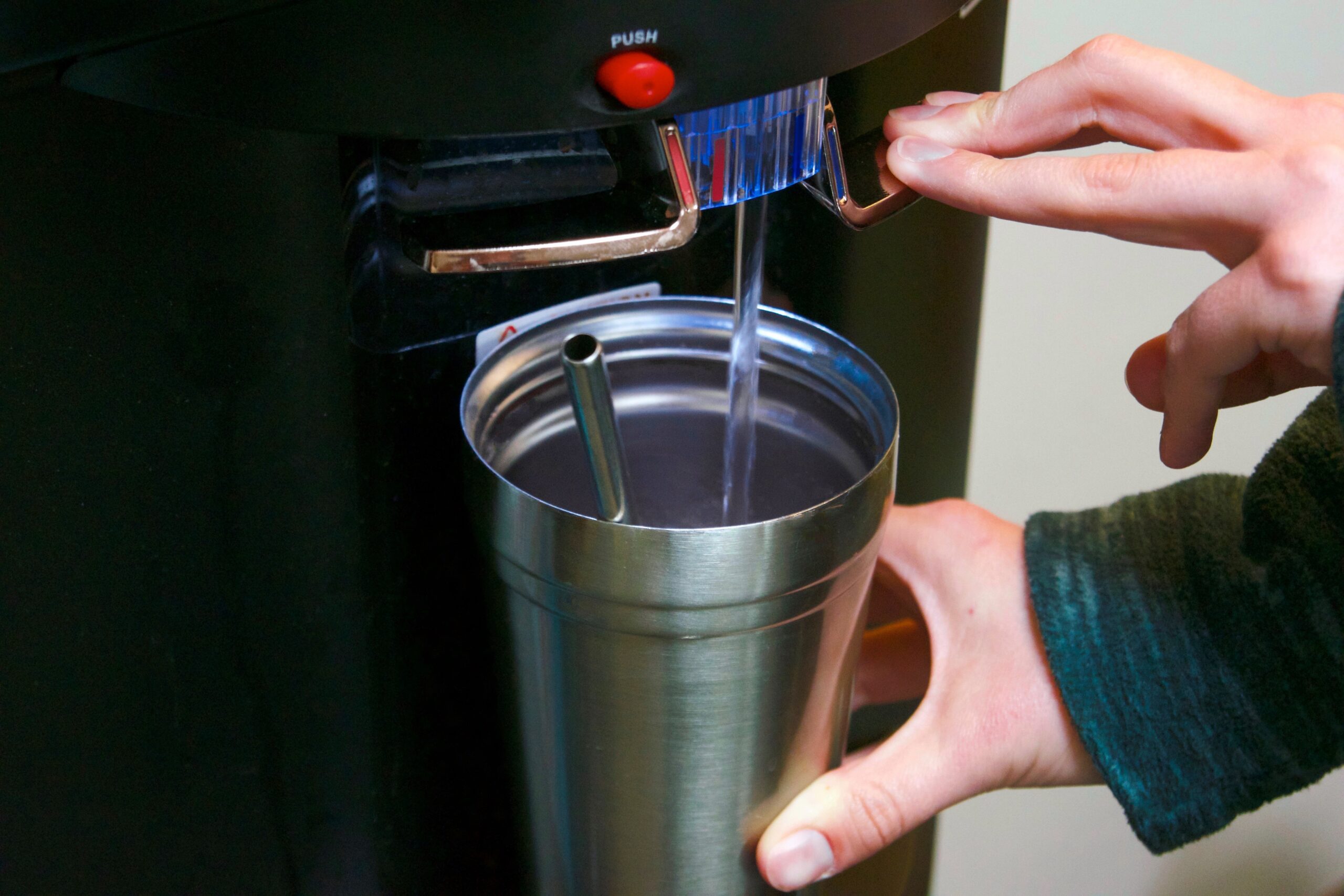 water-2023-11-27-05-25-16-utc employee filling cup at bottleless water cooler