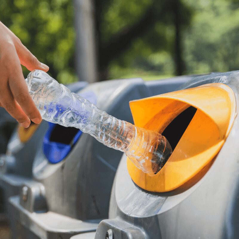 throw-plastic-bottles-into-the-trash- woman recycling plastic in bins