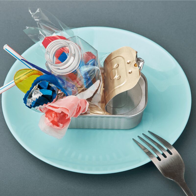 open-tin-can-on-plate-plastic-waste-instead-of-food open tin can and plastic on plate